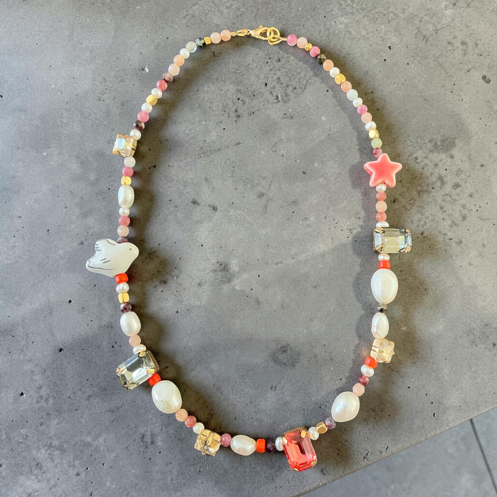 This unique design features a beautiful mix of natural pearls, colourful gemstones, sparkling crystal accents, and delicate beads, carefully arranged to create a soft yet eye-catching piece.