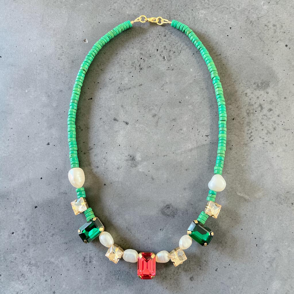 A handcrafted necklace designed with delicate detail and a harmonious blend of natural green tones, pearls, and crystal accents.