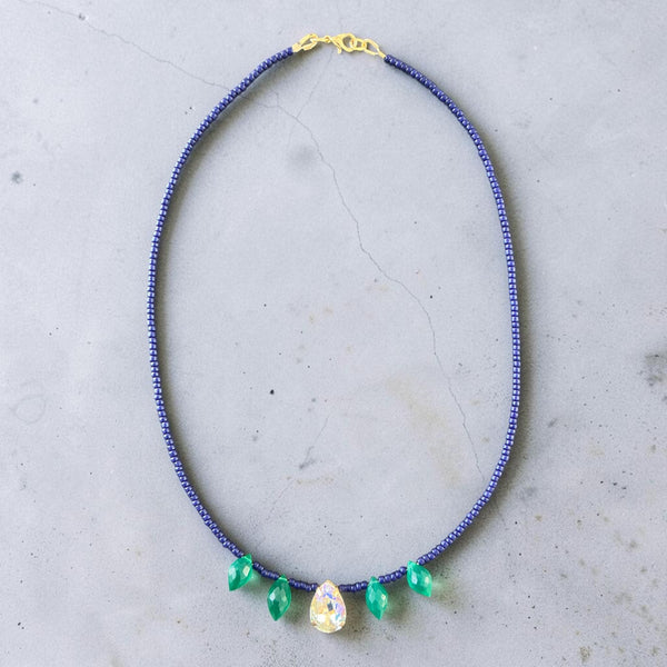 This elegant piece combines rich navy seed beads, shimmering crystal drop accents, and AA+ Green Onyx drop briolettes to create a sophisticated and eye-catching design.
